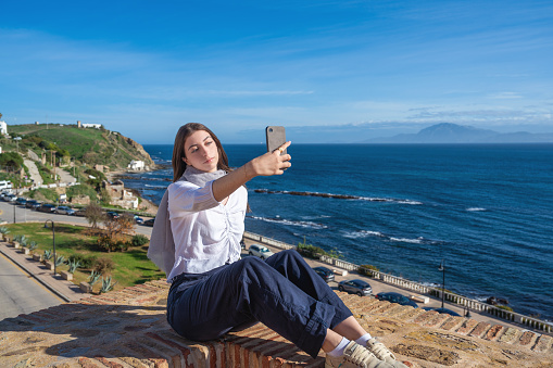 Brunette young woman tourist selfie photo in Tarifa Cadiz surf city of Andalusia Spain