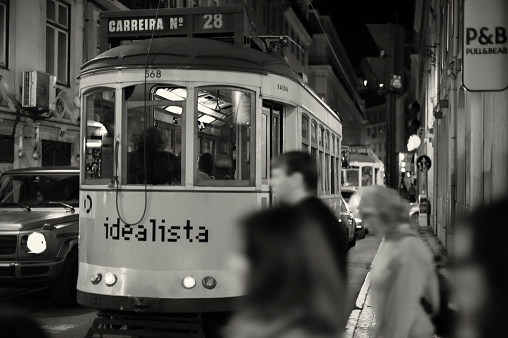 Lisbon, Portugal - December 23, 2023: An old-fashioned tram runs along a street in Lisbon downtown.