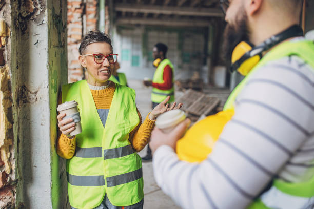 istock Two workers in high visibility vests having a coffee break at a construction site 2132617514