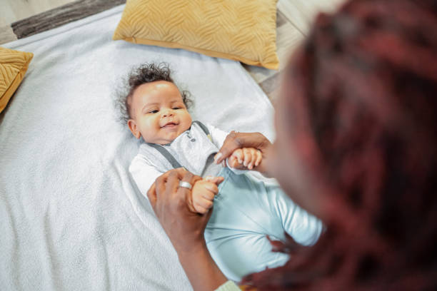 istock Black mother playing with her baby son at home 2132627657