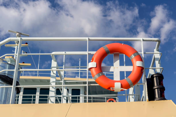 A big red lifebuoy hangs on the ship moored in the marina