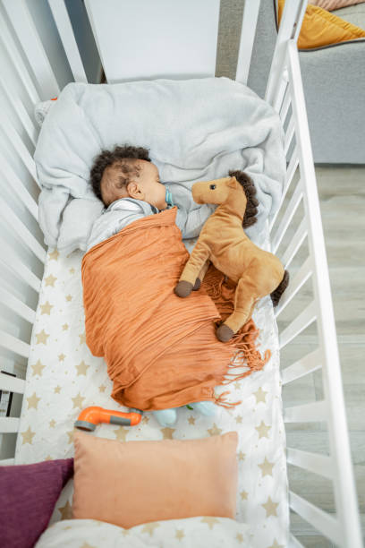 istock Little baby boy sleeping in nursery bed 2132636486