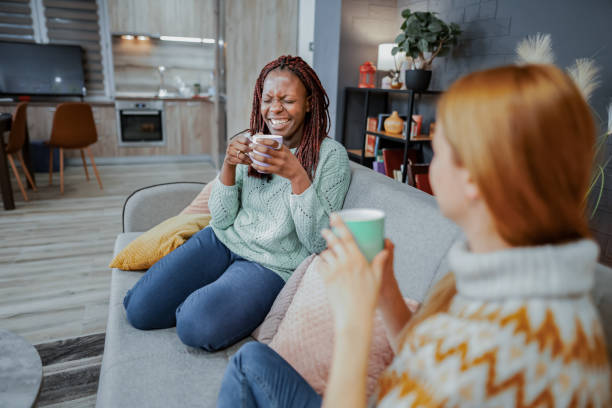 istock Two happy multiracial female friends talking while drinking coffee at home 2132640199