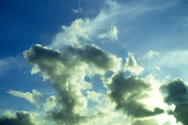 A Landscape with big heavy fluffy clouds on a blue background