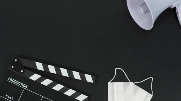 istock Black clapperboard with face mask and megaphone on black background. 2132650621