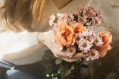 The girl holds a bouquet of flowers in her hands. Soft glow effect