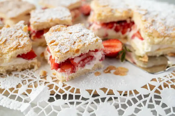 Strawberry sponge cake with delicious cream filling and chopped strawberries and almond topping. Served ready to eat on a platter.