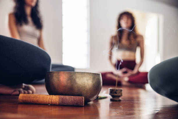 Group of young people doing meditation and relaxing in a open space room sharing positive emotions.