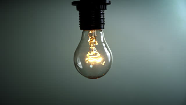 Light Bulb Flashes on a Blue Background in the Dark