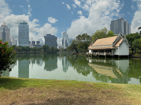 Stock photo showing view of skyscrapers seen from across lake in Lumpini Park.