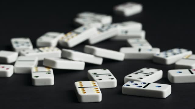 Seamless Domino Chain Reaction Toppling on a Black Surface in Slow Motion