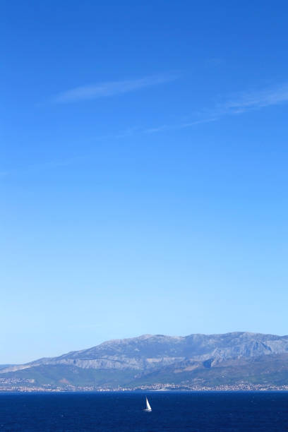 Rocky coast with cliff and green grass. Blue sea