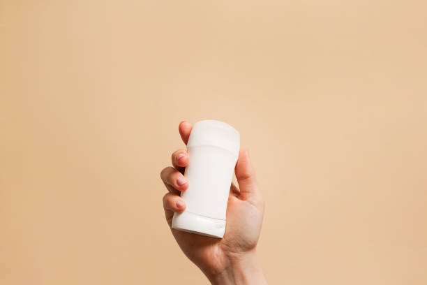 istock Hand holding antiperspirant, white deodorant on beige background, copy space 2132873236