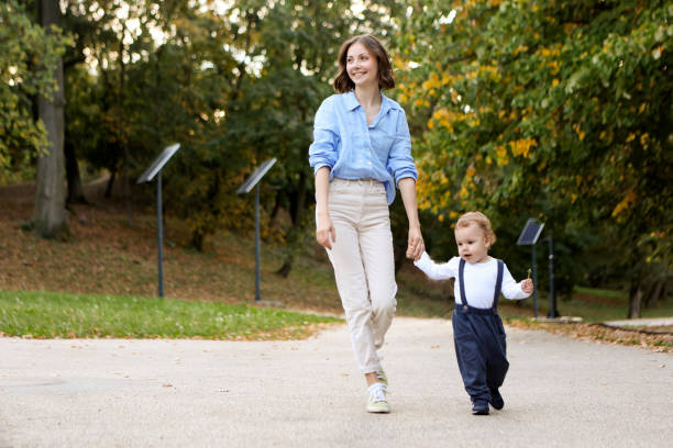 istock Mom and son walking in a park 2132892388
