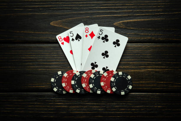 istock Chips and playing cards with a two pairs winning combination on a black vintage table. Concept of winning in a poker club or casino 2132924614