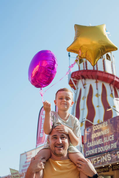Cheerful young Father with his infant son having fun together by seaside, dad throwing up kid in the air