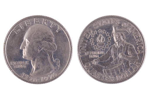 An isolated, silver-colored coin featuring a portrait of a President on the front is shown in the foreground with a plain background