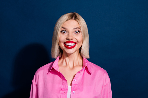 Portrait of ecstatic girl with bob hairdo red lipstick wear stylish shirt staring at sale open mouth isolated on dark blue background.