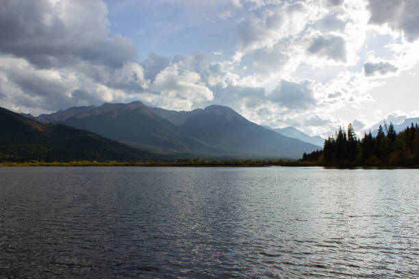 The Vermilion Lakes and Sulphur Mountain full of pine trees, in autumn on a cloudy day near Banff, Canada.