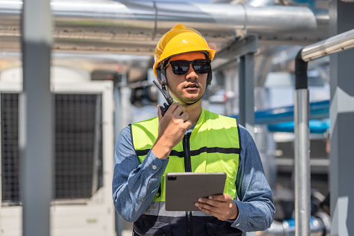 HVAC technician use tablet to record data and conduct real-time analysis. Using specialized software to diagnose and optimize mechanical, electrical, and plumbing systems with energy efficiency plan