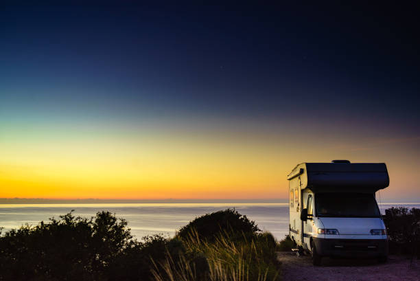 istock Camper vehicle on seashore at sunrise dawn 2133029948