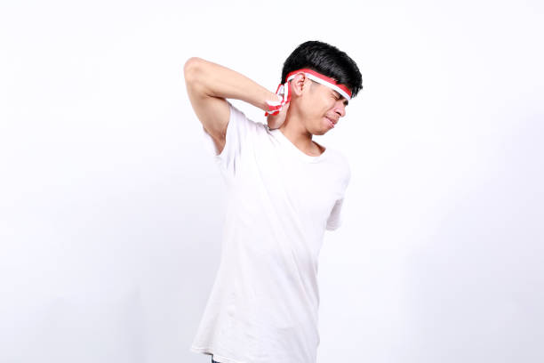 istock Young asian boy with red white ribbon celebrating Indonesia independence day while touching his neck. He have neck ache 2133068494