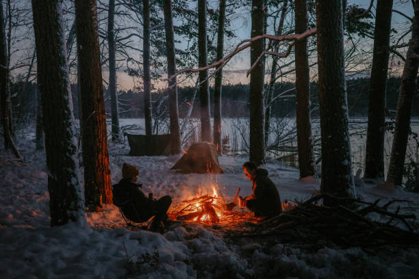 istock Winter holidays in the snow. Two men warming up by the bonfire 2133079080