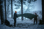 Winter holidays in the snow. Setting up a tent in the woods