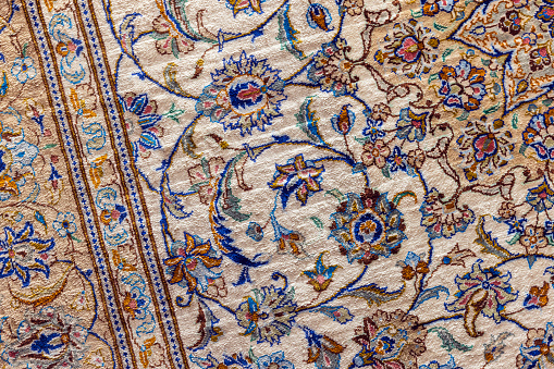 Oriental silk carpet with colorful floral pattern, close-up photo