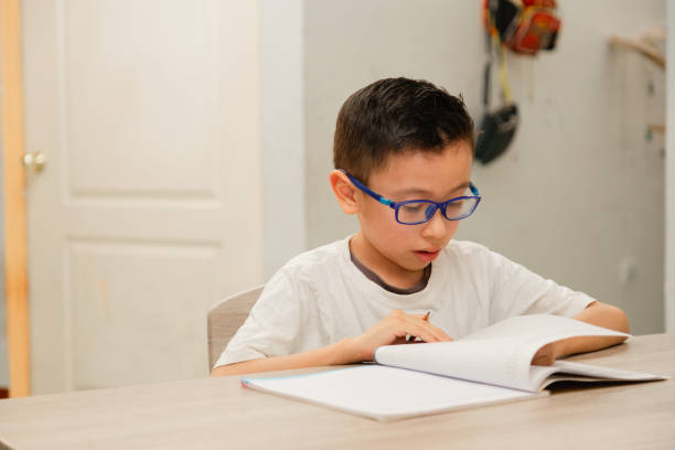 istock Concentrated Hispanic boy doing homework at home - boy writing in his notebook studying from home. Education or back to school concept 2133160002