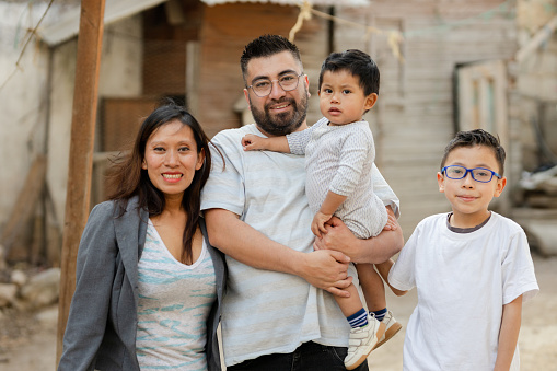 Portrait of happy Hispanic family outside his house in a rural area. Latin family smiling at the camera - Guatemalan family