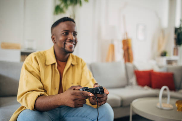 istock Smiling man playing video games at home 2133172037