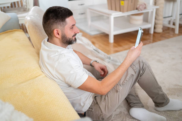 istock Caucaisan man using mobile phone for online shopping at his home 2133173103