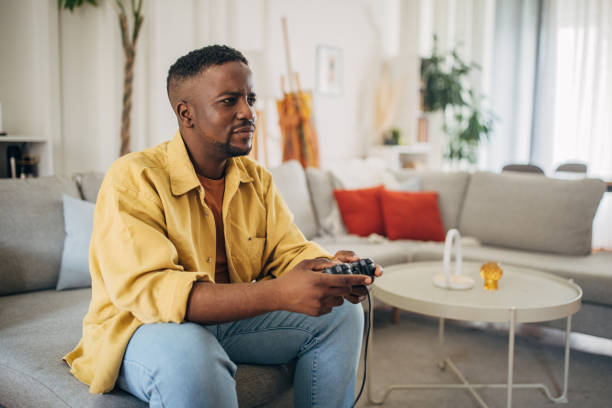 istock Man playing video game in living room 2133175350