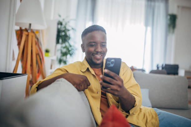 istock Smiling man enjoying time with smartphone at home 2133190809