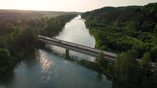 Cars Driving Rural America Bridge Crossing River at Sunset