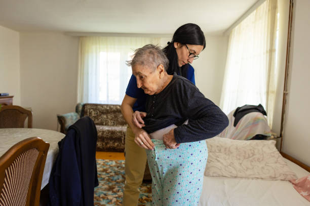 istock Nurse helps an elderly woman to get dressed 2133210329