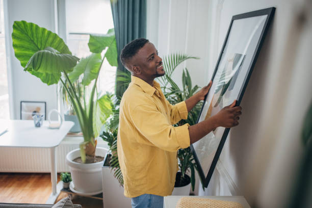 Man adjusting artwork on living room wall