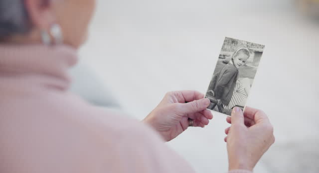 Memory, senior and woman with a photograph or hands in closeup for nostalgia in home. History, retirement and elderly person with retro photography to remember a child with grandmother in house.