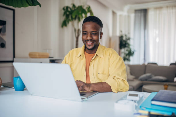 istock Smiling man working on laptop at home 2133239937