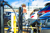 Electric car being charged at charging point in the city