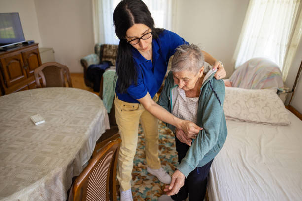 istock Young nurse helping a senior woman get dressed 2133250327