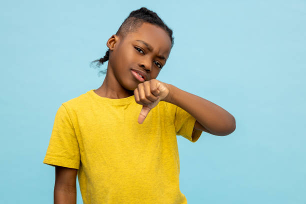 разочарованный афроамериканский маленький мальчик демонстрирует жест неприязни - little boys black african descent american culture стоковые фото и изображения
