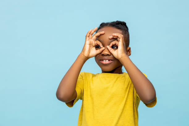 istock Funny dark- skinned little boy looking with hands binoculars 2133250883