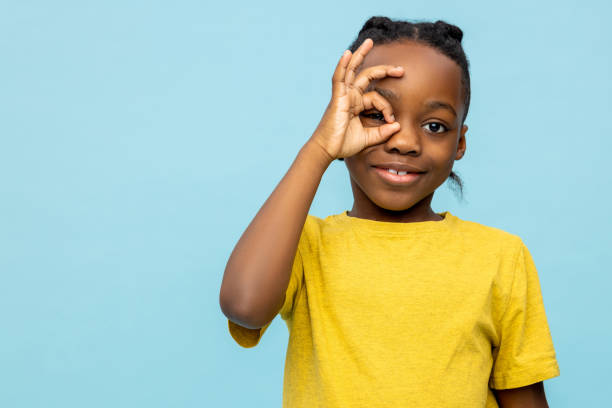 istock Smiling satisfied dark- skinned little boy looking throwing okay sign 2133250886