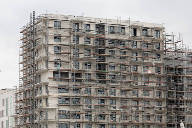 istock A multistory residential building under construction, enveloped in scaffolding, with a clear view of the work in progress against an overcast sky. 2133251945