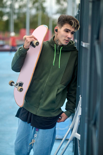 istock Handsome young guy on crutches with a skateboard 2133288051