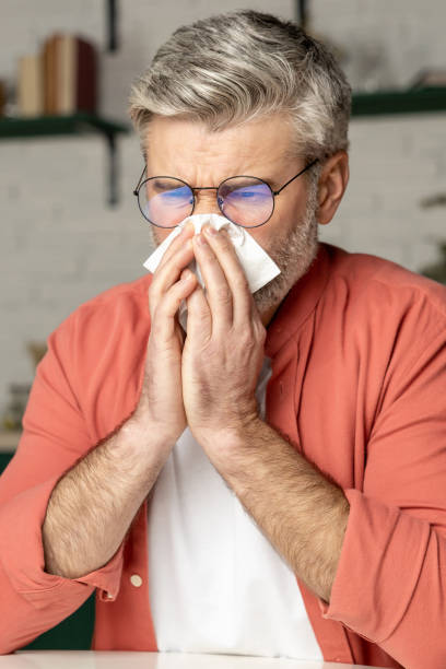 istock Unhealthy man sneezing with handkerchief suffering from cold flu 2133324020