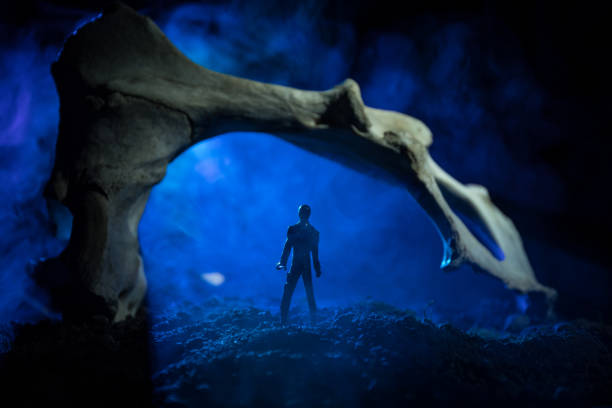 Artwork decoration with animal bone. Silhouette in an underground abandoned crypt. man standing in front of a cave entrance. Selective focus