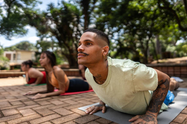 Young man on yoga class outdoors